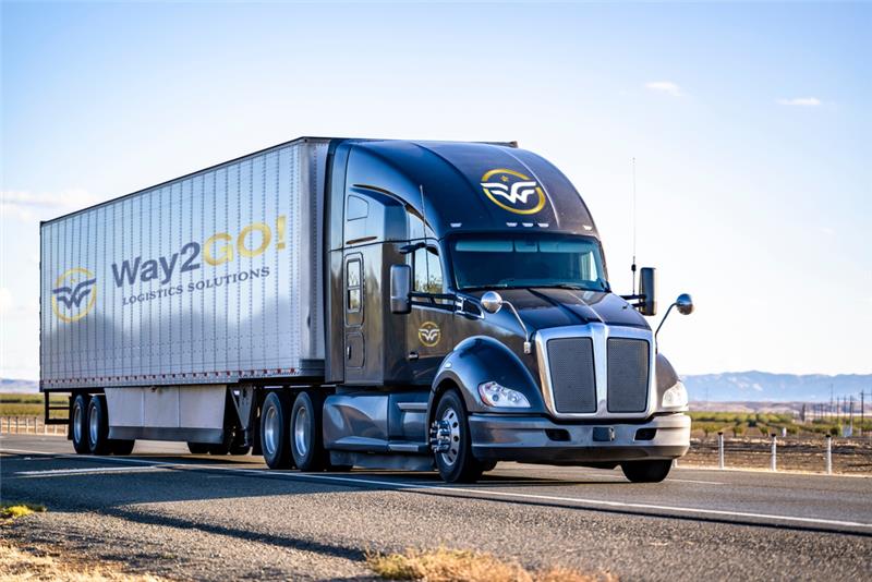 Navy blue Kenworth truck with Way2GO! Logistics Solutions branding on silver trailer